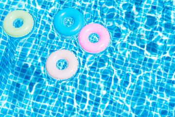 Top view of various colors floats in the pool. Summer concept. Illustration 3d