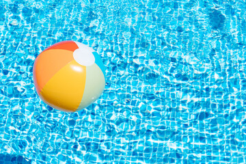 an inflatable ball on a pool water background. concept of summer and travel. copy space