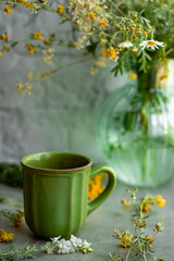 herbal tea mug shot from above through a bouquet of wildflowers and herbs.morning tea in the village