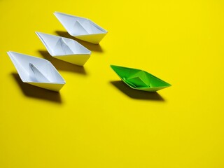 white and green paper boat yellow background in an orderly manner, providing ideas, leadership and effective management give a feeling have solidarity success, love, happiness, great