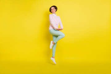 Fototapeta na wymiar Full length body size photo of funky pretty female student jumping up smiling isolated vivid yellow color background
