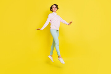 Fototapeta na wymiar Full length body size photo of cheerful model jumping up stepping forward gracefully isolated vibrant yellow color background