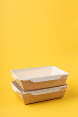 Disposable food delivery boxes on yellow background