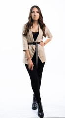 young girl posing on a white background. teenager in black pants, boots and a beige jacket