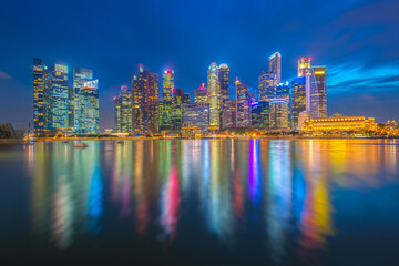 A modern urban landscape or economy in Singapore's business district with skyline and lights from the city center buildings and nightlife at Marina Bay, Singapore.