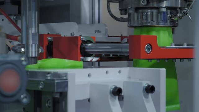 Automatic blow molding machine - manufacturing of empty green plastic jerrycans at factory, exhibition. Industry, packaging, automated technology equipment concept