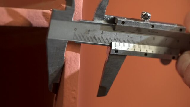Measuring metal piece with vernier caliper. Worker conducts defect diagnosis of parts in production. High quality FullHD footage