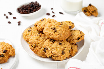 Homemade oatmeal cookies with raisins in a white plate on a light background closeup	