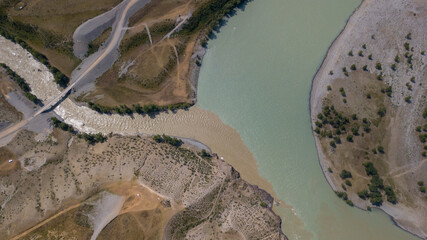 Aerial view of the confluence of the Chuya and Katun rivers with a bridge over the muddy waters of the Chuya river, Altai photo by drone