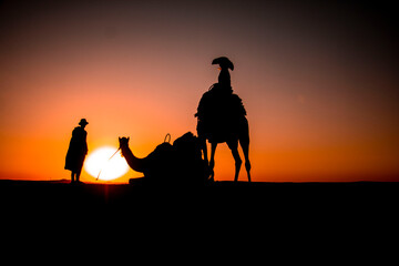 woman in a dress on a camel with guide