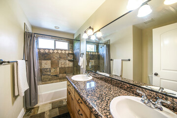 Bathroom interior with marble tiles and double vanity sink with granite top