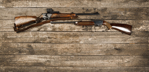 Hunting weapon on dark wooden backgorund, top view