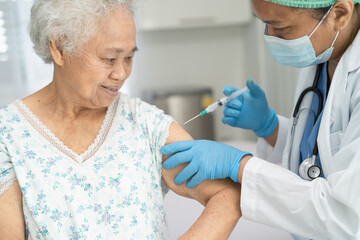 Elderly Asian senior woman wearing face mask getting covid-19 or coronavirus vaccine by doctor make...