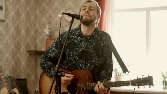 Man playing guitar and singing during rehearsal