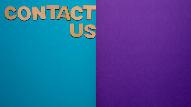 Wooden letters with the words "contact us" in the upper left margin of the image on a blue and purple background