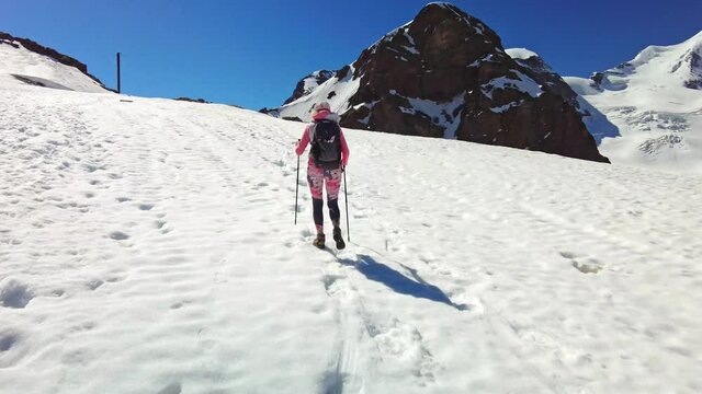 HYPER-LAPSE: backpacker girl walking with trekking poles on top of Diavolezza col. Munt Pers and Piz Trovat of Switzerland in Graubunden canton.