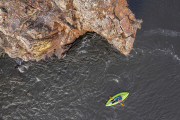paddling a whitewater inflatable kayak on a mountain river in early spring - Poudre River in northern Colorado, aerial view