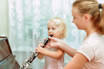 A young teacher shows how to play the clarinet correctly.