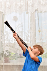 The boy plays the clarinet at a music school. - obrazy, fototapety, plakaty