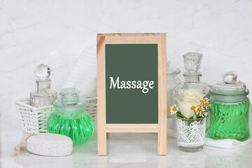 Tafel mit dem Text Massage und verschiedene Wellness Produkte.