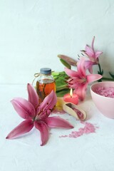 
Fresh flower, burning candles, sea salt, oil and herbal tincture on the table, natural cosmetics for care and relaxation