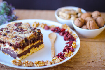 Piece of tasty chocolate-nut cake on a clay plate. Walnuts and p