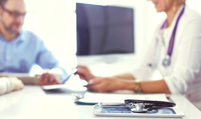 Doctor in clinic asking senior woman in wheelchair for a signature