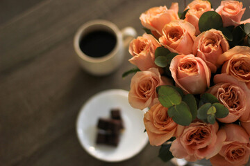 A bouquet of pink roses stands on the table in a vase