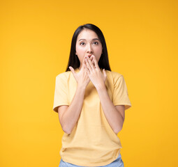 Young Asian woman making hand gesture with surprise face. Happy Asian woman wearing yellow t-shirt standing over yellow background. Portrait of happy Asian female .