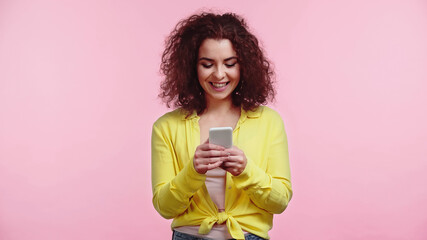 cheerful woman chatting on cellphone isolated on pink