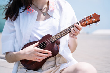 woman playing ukulele in the street