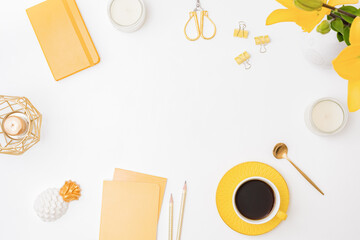 Flat lay workspace with notebook, cup of coffee and yellow lilies on white background