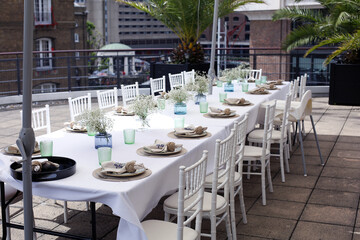 Table setting on a posh roof setting in the city ready for a summertime al fresco dinner party