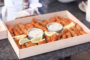 A box of freshly made chicken goujons with lemon slices and tartar sauce
