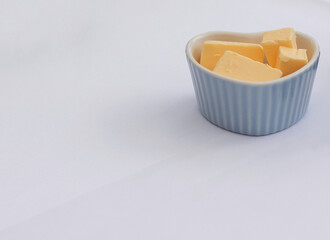 Heart shaped dish of butter on white background