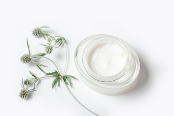 Fototapeta na wymiar Moisturizing face cream in a glass jar on a white background. Purifying face mask with natural extracts and ingredients.