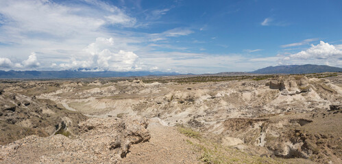 Los Hoyos landscape at colombian Tatacoa Desert with andes mountains and blue sky at background in sunny day.  