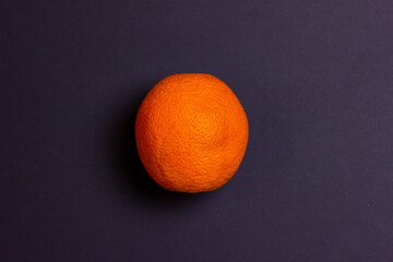 Orange on a black background. Bright citrus. Orange ball on a black background. Orange texture