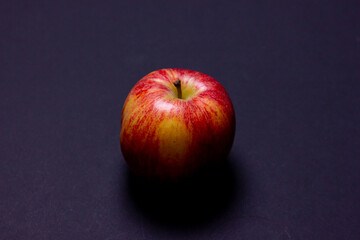 An apple on a black background. Red apple side view. A ripe apple.