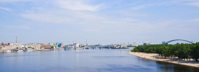 Scenery. View of a deep river in the middle of a big city. Embankment, beaches and urban development on the horizon.