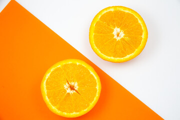Close up photo of Orange Fruit on the white and orange background. Citrus cut in half, inside, macro view. Minimalism, original and creative image. Beautiful natural wallpaper.