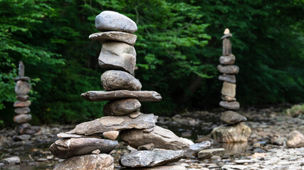 Fototapeta na wymiar Rough Stone Cairns Standing Proudly in the Shallow Creek Water