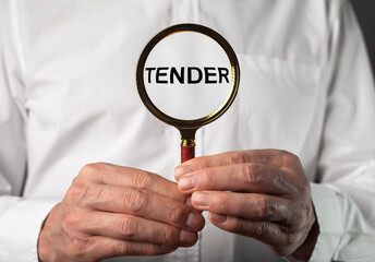 Business tender concept. Word through magnifying glass