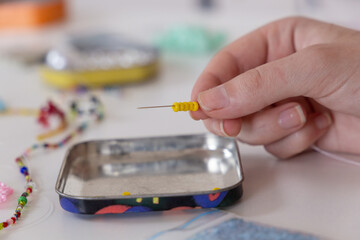 Closeup of needle with beads on it. The process of deading handicraft. Beautiful diy jewelry and calming stress releasing hobby and activity