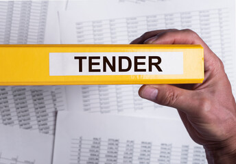 Tender word on office folder in male hand. Business procurement concept