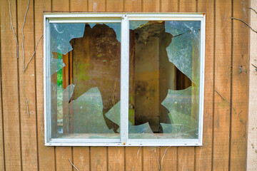 Broken dirty glass of window of an old wooden house in Washington State