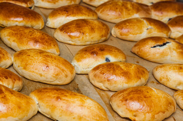 Baked buns stuffed with currant jam on parchment paper.