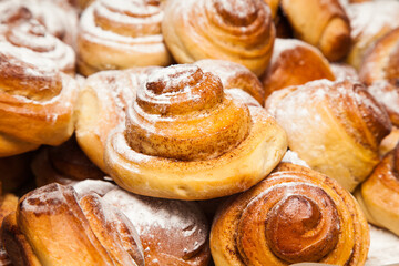 Homemade baking. Baked cinnamon rolls sprinkled with powdered sugar.