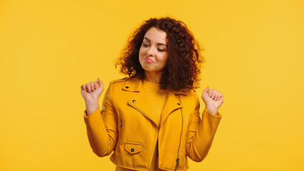 proud young woman in leather jacket isolated on yellow - obrazy, fototapety, plakaty