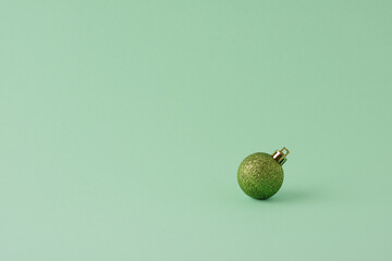 Christmas pastel green minimal background with green ball. Close up, copy space